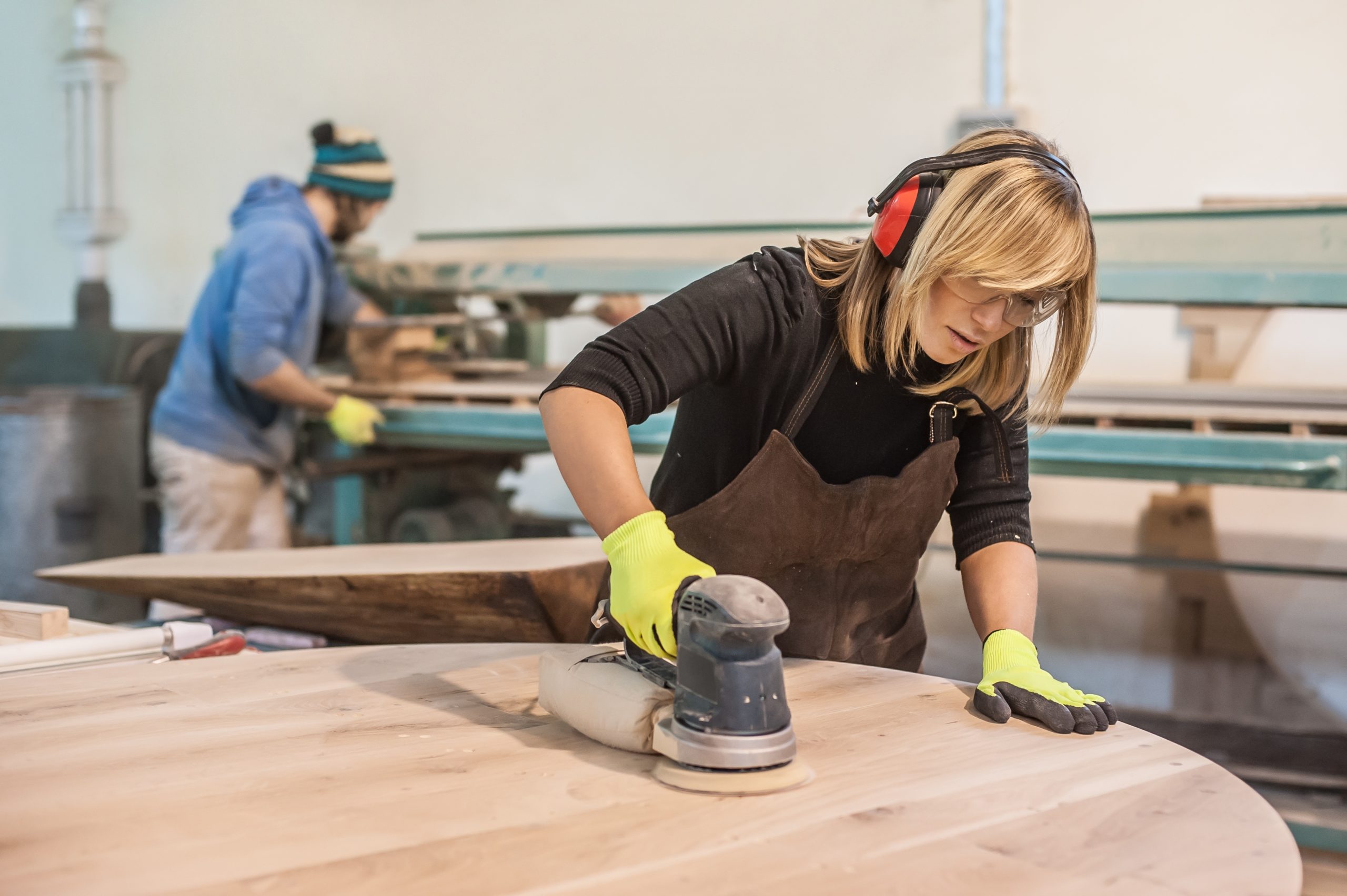 Female Carpenter Using Electric Sander