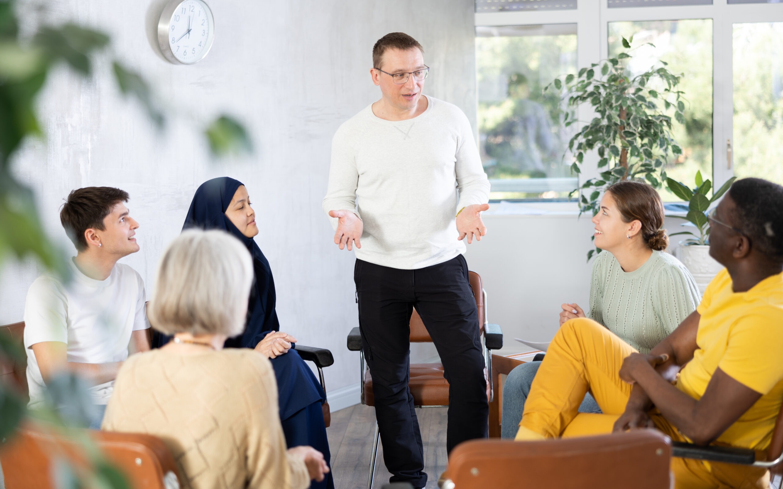 Smiling Man Conducting Informal Work Meeting With Colleagues